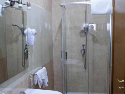 La salle de bains est pourvue d'une douche vitrée. dans l'établissement Hotel Serena, à Naples