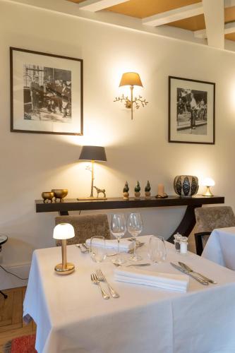 a white table with wine glasses and a lamp at Demeure d'Hôtes Haec Otia in Le Touquet-Paris-Plage