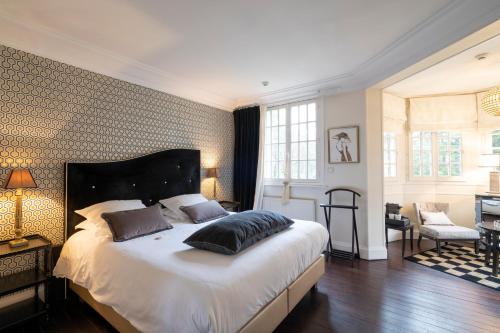 um quarto com uma cama grande e uma sala de estar em Demeure d'Hôtes Haec Otia em Le Touquet-Paris-Plage