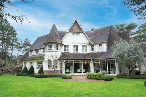 a large white house with a large yard at Demeure d'Hôtes Haec Otia in Le Touquet-Paris-Plage