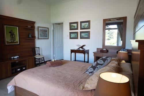 una camera con letto, scrivania e finestra di Guildwood Villa Bali a Sanur