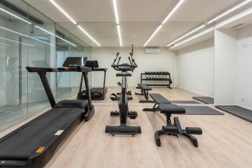 a gym with treadmills and exercise equipment in a room at Luxurious & Premium Flat - Pool & Gym in Tavira