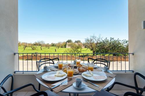 a table with food and orange juice on a balcony at Luxurious & Premium Flat - Pool & Gym in Tavira