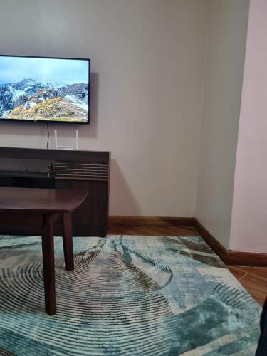 uma sala de estar com uma televisão de ecrã plano na parede em C & T luxury apartments em Nakuru