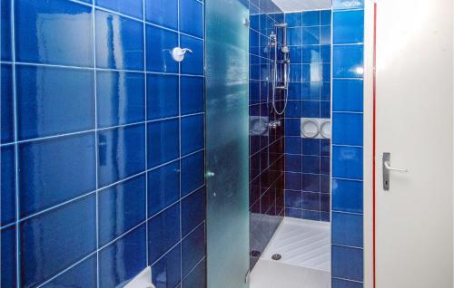 W wyłożonej niebieskimi kafelkami łazience znajduje się prysznic i toaleta. w obiekcie Holiday Village w Lignano Sabbiadoro
