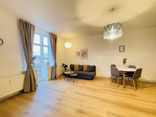 a living room with a couch and a table at aday - The Swanky Suite in Hjørring