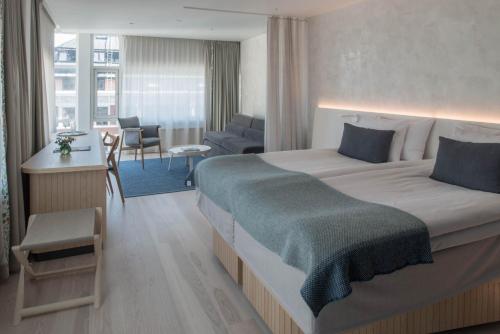 ストックホルムにあるノルディック ライト ホテルのベッドルーム(大型ベッド1台付)、リビングルームが備わります。