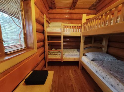 a bedroom with two bunk beds in a log cabin at Шале Гірська Казка in Yaremche