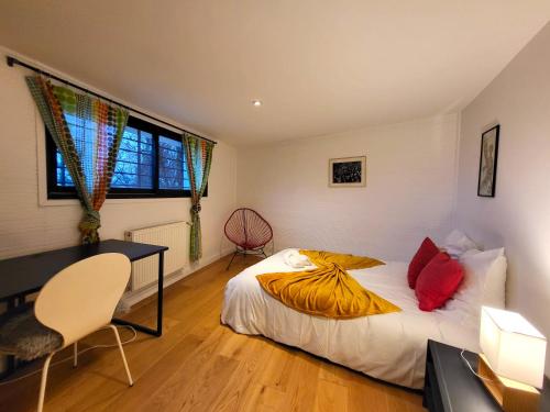 a bedroom with a bed and a desk and a window at 360 : Superbe maison, rooftop, vue Tour Eiffel, T2 in Meudon