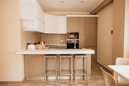 a kitchen with white cabinets and a white counter top at Affittacamere Mira Sinni in Episcopia