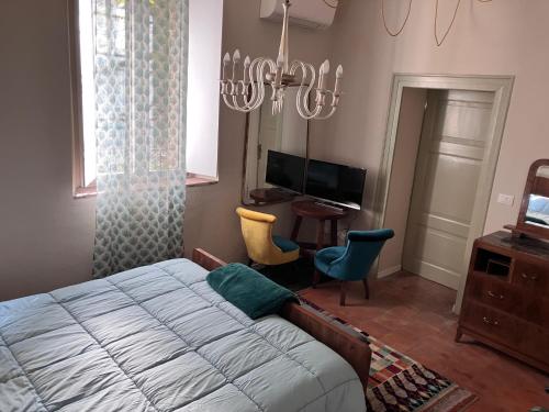 - une chambre avec un lit, un bureau et un lustre dans l'établissement Appartamento in Cascina Cortazza, à Crémone