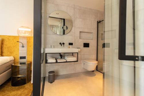 a bathroom with a sink and a toilet and a mirror at Grand Hotel Beatrix in Den Helder