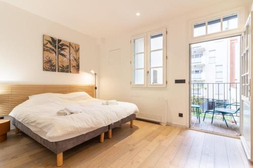 - une chambre avec un lit et un balcon dans l'établissement Wonder Appart' 402 - Vue sur Garonne, à Toulouse