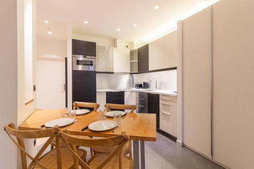 a kitchen with a wooden table and chairs at Wonder Appart' 402 - Vue sur Garonne in Toulouse
