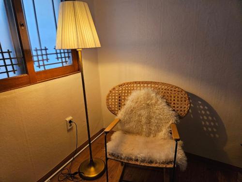 a lamp sitting next to a wicker chair next to a lampost at Jamsil Geram in Seoul