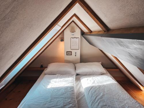 two beds in a attic bedroom with a window at Kyritzer Budenhaus Nr 103 in Kyritz