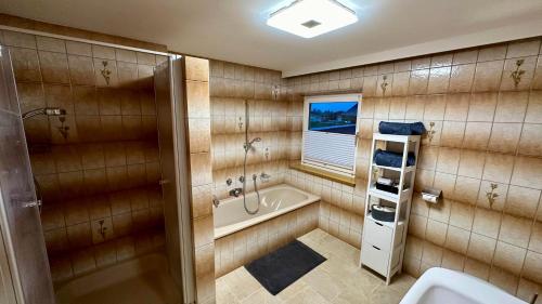 y baño con bañera, ducha y lavamanos. en Haus Wurzenrainer, en Sankt Johann in Tirol