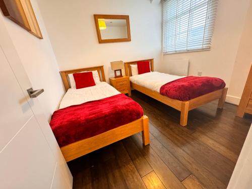 twee bedden in een kleine kamer met een raam bij Ideal for Contractors in Reading with Free Parking in Reading