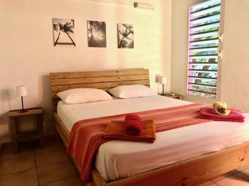 a bedroom with a large bed with towels on it at Mabouya chez Villas Piment Café in Deshaies