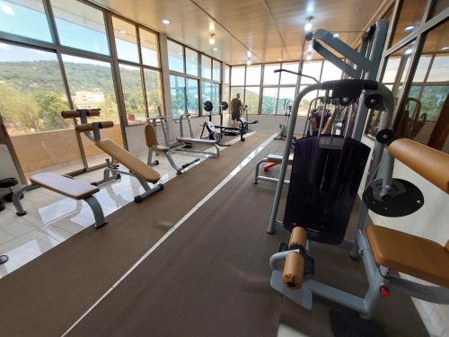 a gym with a row of treadmills and machines at La Couronne Suites in Bangui