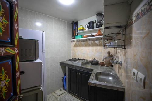 a small kitchen with a sink and a refrigerator at 105 Kasbah de Boujloud Fes Morocco. in Fez
