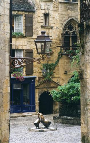 two statues in front of a building with a street light at Le Bonheur in Payrac