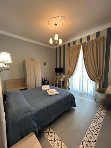 a bedroom with a blue bed and a living room at DIMORA LE PIETRE DEL MARE in Pizzo