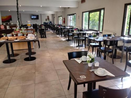 un comedor con mesas y sillas en un restaurante en Hotel Hurlingham en Villa Carlos Paz