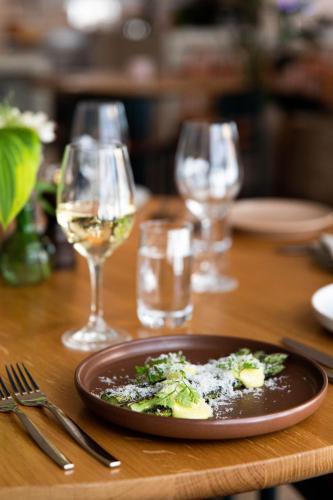 a plate of food on a table with glasses of wine at Nordic Light Hotel in Stockholm