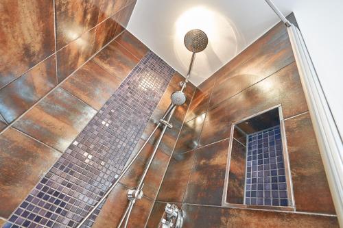 een badkamer met een douche met bruine tegels bij Schützenstraße 15 La Mer in Grömitz