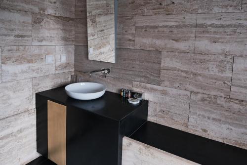 a bathroom with a bowl sink on a black counter at Hotel Pod Różą in Kraków