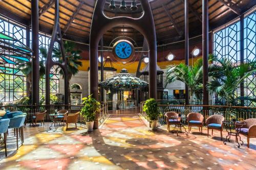 a large lobby with a clock in a building at Hotel Cordial Mogán Playa in Puerto de Mogán