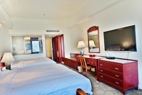 a hotel room with two beds and a flat screen tv at T Hotel in Taichung