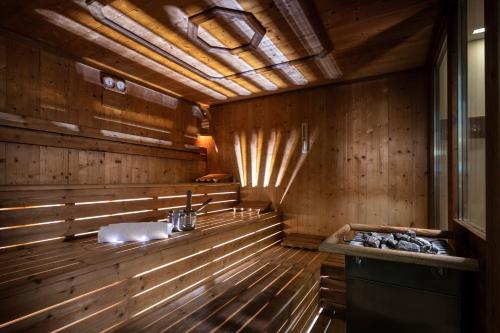 eine Sauna mit Waschbecken in einem Holzzimmer in der Unterkunft Hotel Überbacher in Lajen