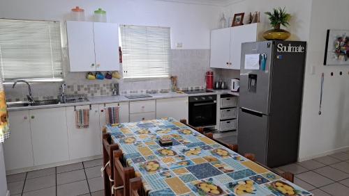 a kitchen with a table and a refrigerator at Smartie Box in Langebaan