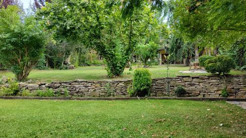 a stone wall in a yard with trees and grass at Villa Lana chalet Baros, Jaca in Jaca