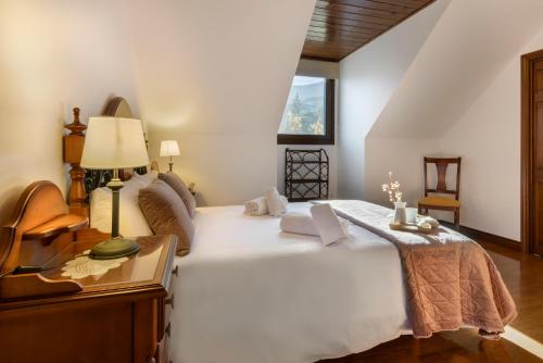 a bedroom with a large white bed and a table at Villa Lana chalet Baros, Jaca in Jaca