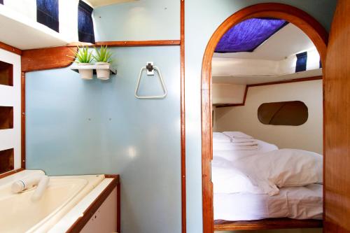 um pequeno quarto com uma cama e um espelho em Evamia Boat em Lisboa