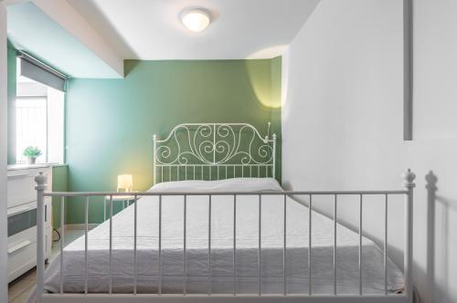 een slaapkamer met een bed en een groene muur bij Seafront Apt with View in Aci Castello in Aci Castello