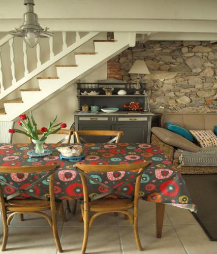 une salle à manger avec une table et des chaises et un escalier dans l'établissement Maison de pêcheur aux Sables dOlonne Entre Océan, à Les Sables-dʼOlonne