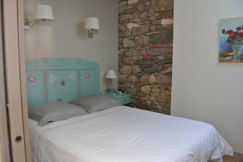 une chambre avec un lit et un mur en pierre dans l'établissement Maison de pêcheur aux Sables dOlonne Entre Océan, à Les Sables-dʼOlonne