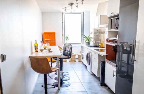 a kitchen with a table and chairs in a room at Luxe calme et volupté avec vue panoramique sur le vieux port in Marseille