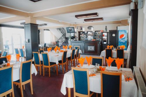 MOTEL POPAS TALMACIU في تالماسيو: مطعم بطاولات بيضاء وكراسي زرقاء