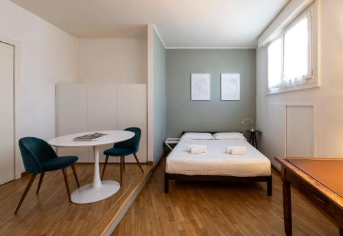 una camera con letto, tavolo e sedie di Amazing studio in San Babila a Milano