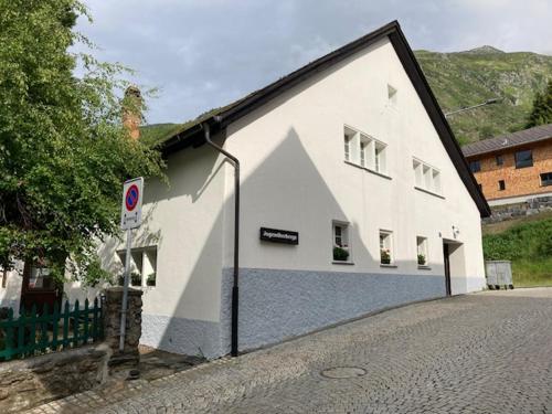 a white building on the side of a street at Jugendherberge Hospental in Hospental