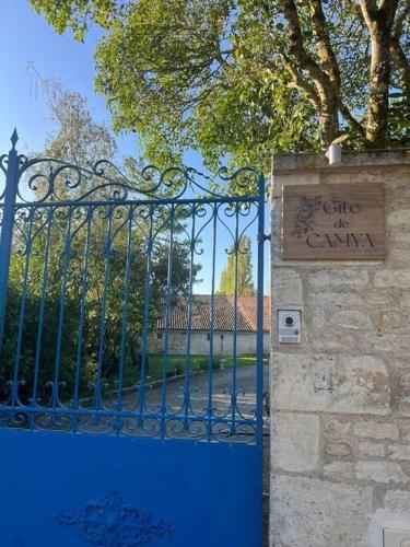 a blue gate with a sign next to a building at Gîte de Camya à Coulon in Coulon