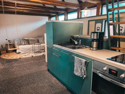 a kitchen with green cabinets and a stove top oven at Kyitzer Budenhaus Nr. 99 in Kyritz