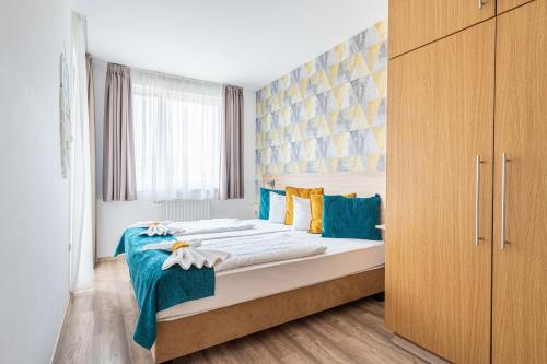 a bedroom with two beds with blue and yellow pillows at Nova Apartments in Budapest