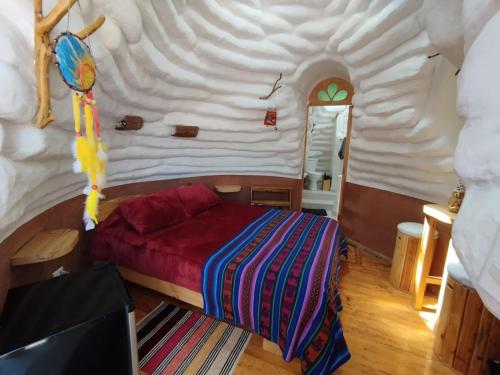 una camera da letto con un letto in una stanza grande di DOMOS PUJLLAI San Pedro de Atacama a San Pedro de Atacama