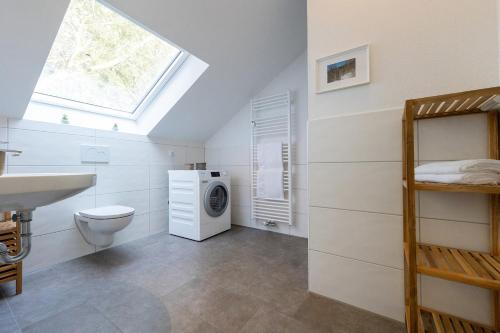 a bathroom with a toilet sink and a washing machine at LM9-3-3 - Ferienwohnung Wremer Bogen Komfort in Schottwarden